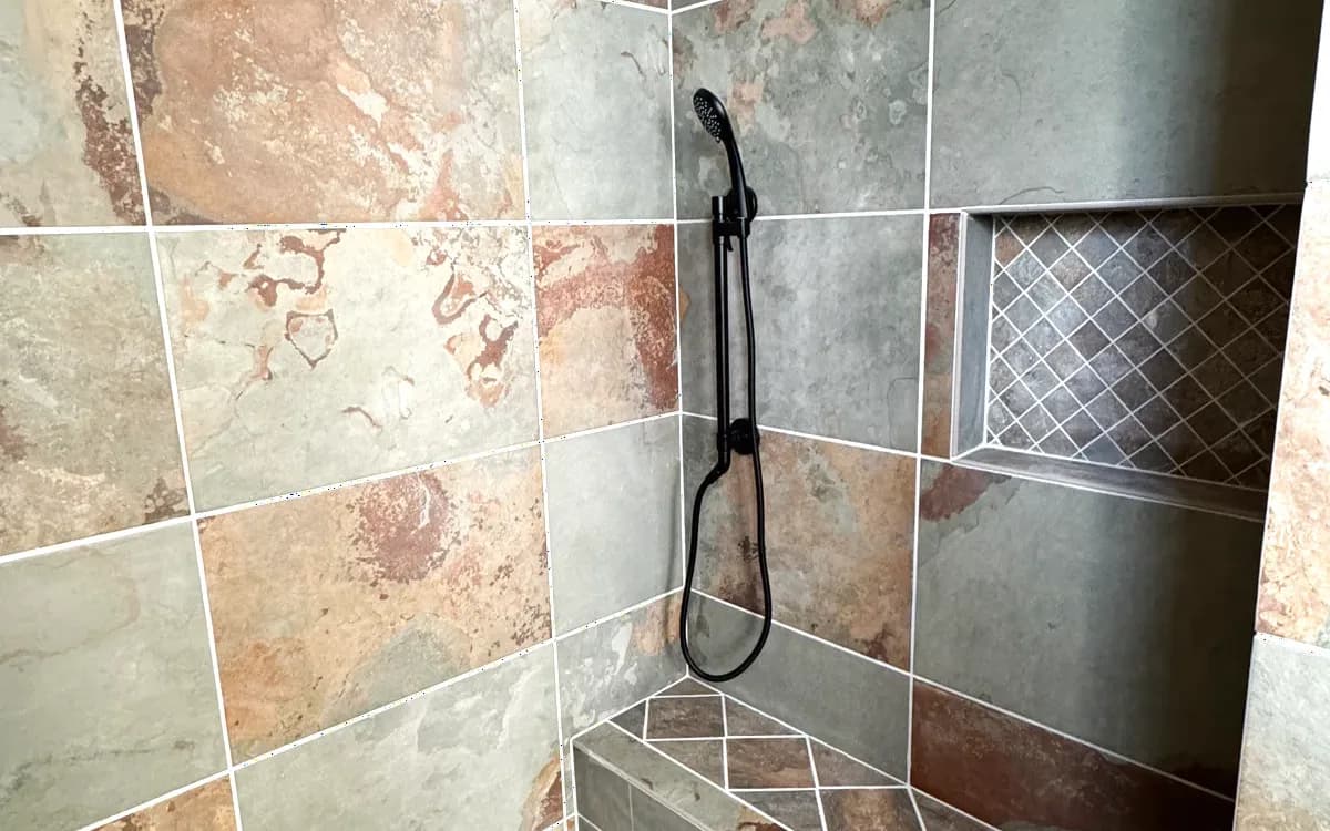 Shower interior with recessed niche, bench and handheld on slide bar