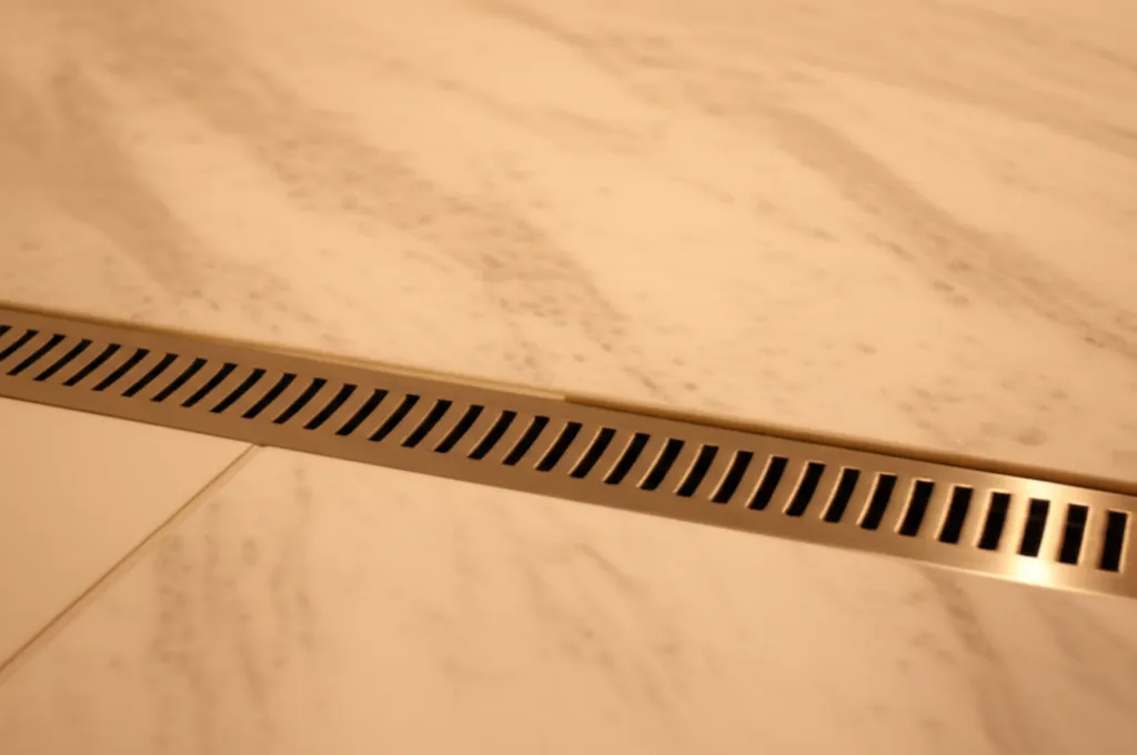 Custom linear drain creates a seamless transition from bathroom floor to shower floor